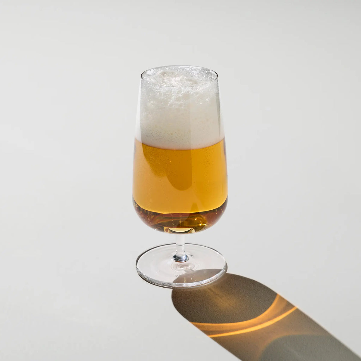 Sæt med 2 Brewer’s Beer Glass fyldt med gylden øl – elegante ølglas med skumkrone og klarhed, perfekte til ølentusiasten.